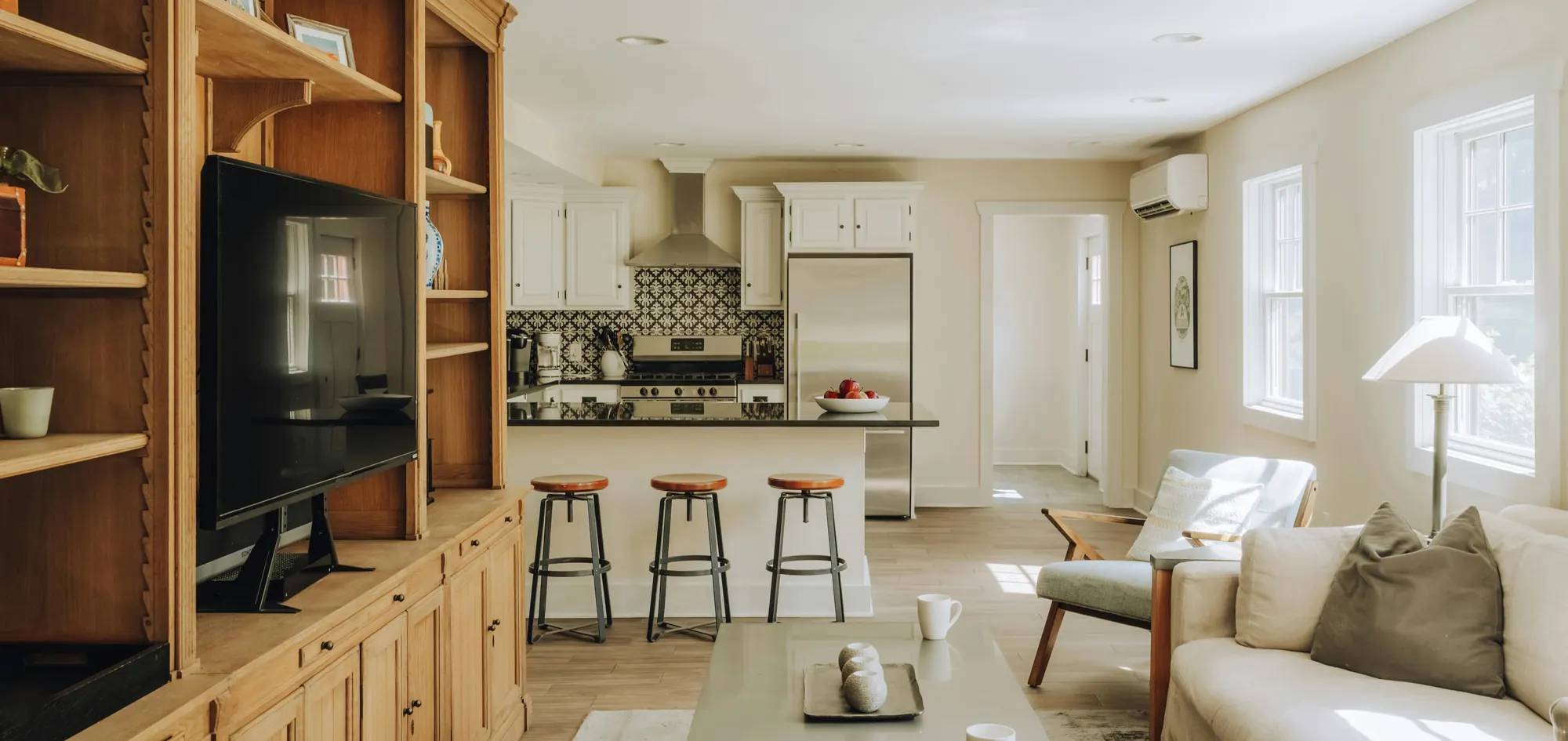 Living room and kitchen fitted with a smart TV, split AC, refrigerator, cooker and lighting