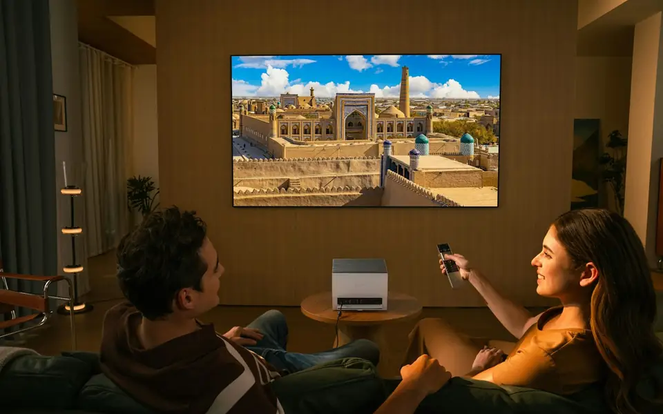 Family watching a large wall screen in the living room